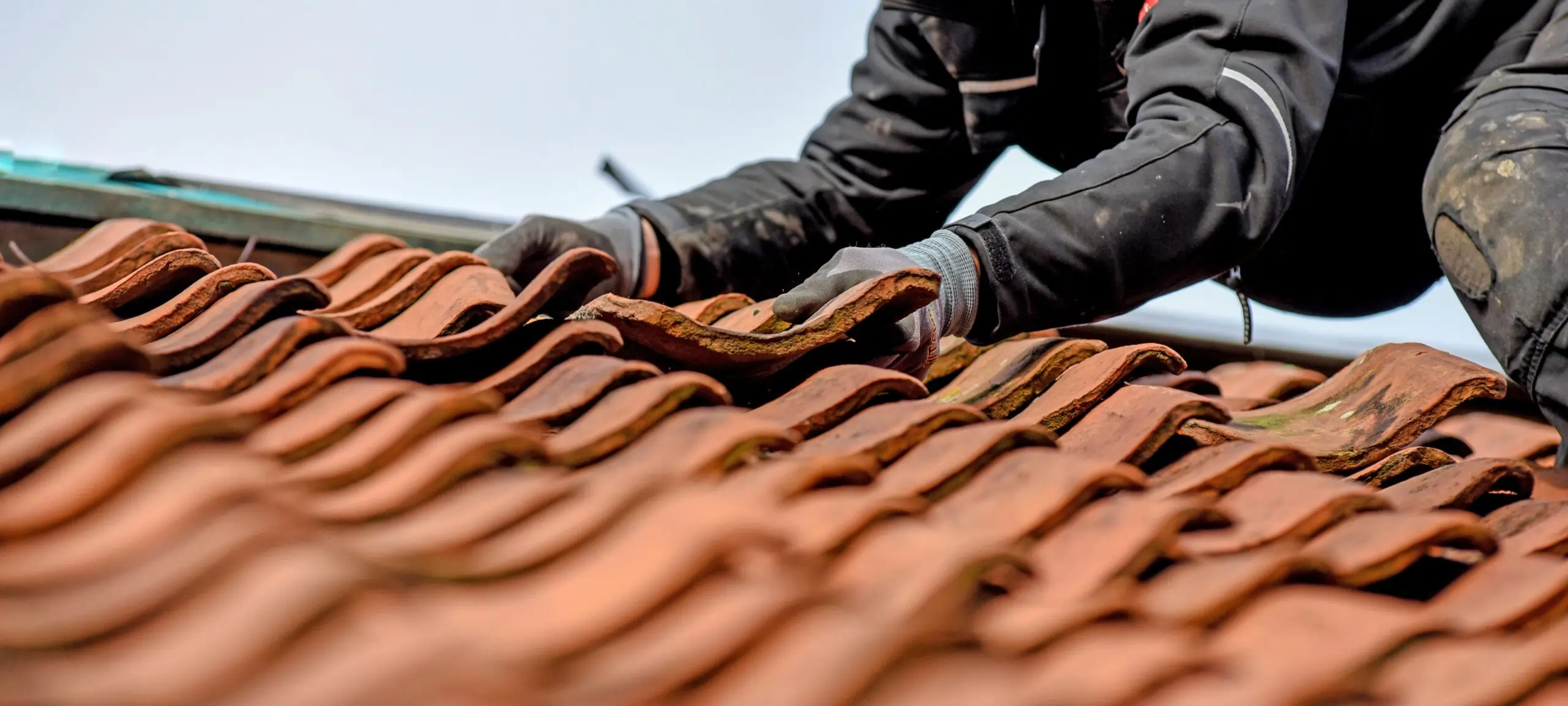 Professional carrying out tile roof repair Bristol on residential pitched roof
